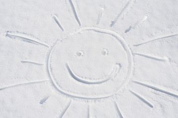 smiling sun in the snow. drawing of the sun on a winter snowdrift