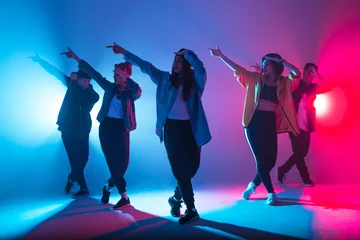  Jonge moderne dansgroep van zes volwassen jongeren oefenen dansen op kleurrijke achtergrond © alfa27