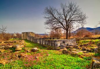 Fototapeta na wymiar Solid stone wall and ruins of ancient fortress