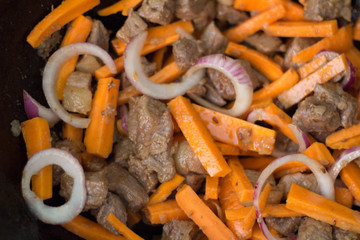 Fry carrots for cooking pilaf meat with rice on fire in the cauldron. Recipe
