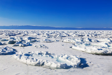 Fototapeta na wymiar View of the frozen lake Baikal on a Sunny day. Irkutsk region, Russia