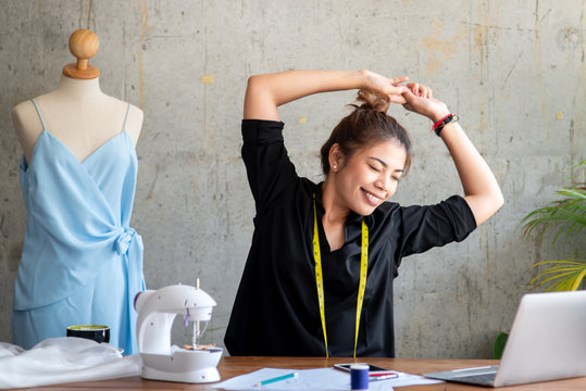 Young designer stretching herself while work in studio, work lifestyle concept.
