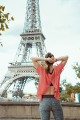 young woman jogger in front of Eiffel tower in Paris, France