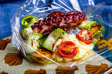 Luxurious seafood platter: octopus with vegetables. Banquet festive dishes. Fine dining restaurant menu. White background.