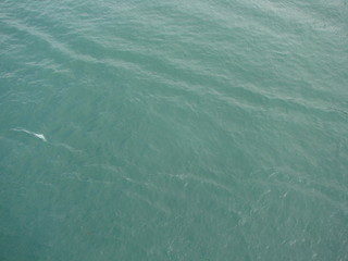 A view from the deck elevation of the ocean liner to the amazing shades of sea blue under the sun rays.