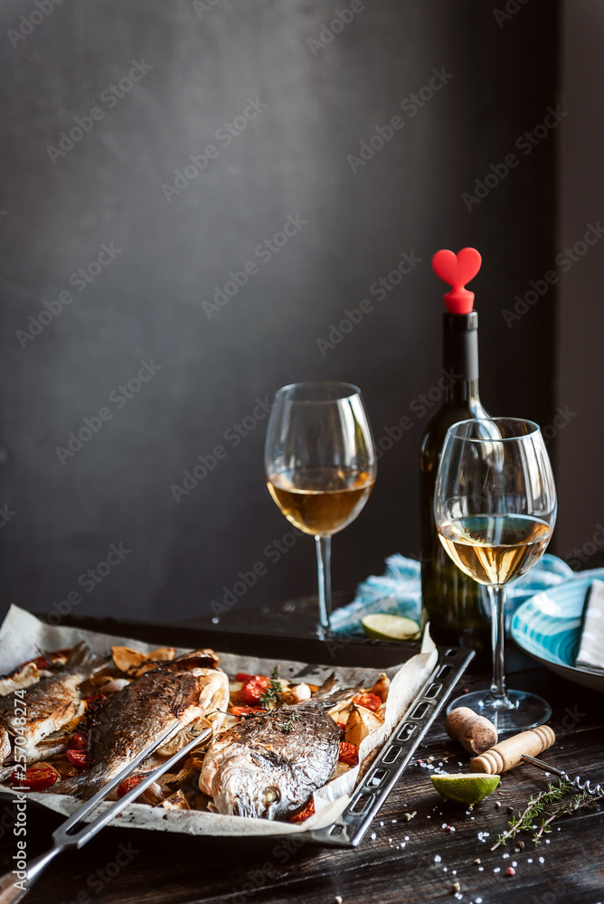 Wall mural dinner concept for two. two glasses of white wine, baked fish. - Wall murals
