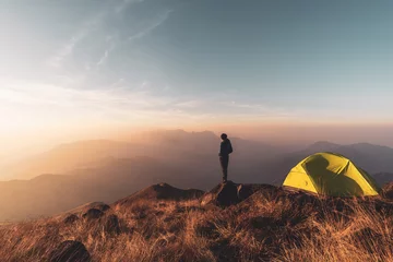 Foto auf Acrylglas Camping Reisender junger Mann, der Landschaft bei Sonnenuntergang und Camping auf dem Berg betrachtet, Abenteuerreisen-Lifestyle-Konzept