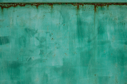 Green metal dirty sheet fence. Rust grunge leaks template blank. Old paint on the fence. Copper abstract wall art