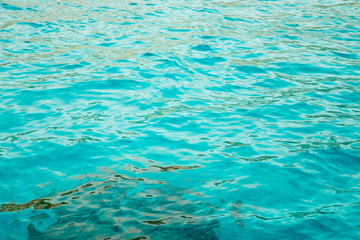 Fototapeta na wymiar Blue clear water. Beautiful blue sea wave photograph close up. Beach vacation at sea or ocean. Background to insert images and text. Tourism, travel.