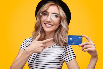 Cheerful female pointing at bank card