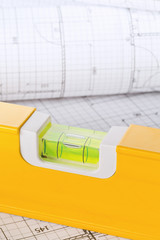 Orange construction level on architectural blueprint building plan close up
