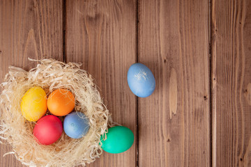 Obraz na płótnie Canvas Colorful Easter eggs on wooden background with copy space