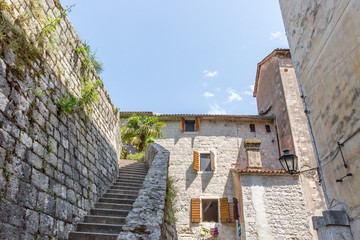 A narrow dead end alley with a staircase and stone doorway leading to apartments in the medieval...