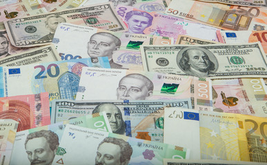 Money and finances concept. One hundred dollar new bill on colorful abstract background of Ukrainian, American and euro national currency banknotes