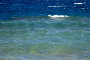 Waves in the ocean. Beautiful blue sea wave photograph close up. Beach vacation at sea or ocean. Background to insert images and text. Tourism, travel.