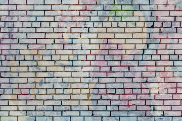 Beautiful horizontal texture of part of an old crashed brick colored wall in yellow red blue green brown hue on the photo