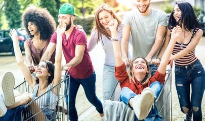 Young multiracial people having fun together with shopping cart - Millenial friends sharing time...