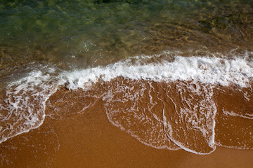 Beautiful coastline with sand and water. blue sea wave photograph close up. vacation at sea or ocean. Background to insert images and text. Tourism, travel.