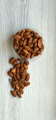 Healthy food  for background image close up almond nuts. Texture on white grey table top view. Nut on the cup plate