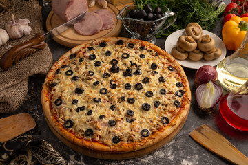 Pizza with ham, mushrooms, black olives and onions