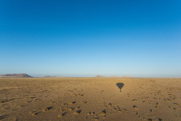 Shadow of a hot air balloon during landing in the Namib Desert, Solitaire, Namibia, Africa.