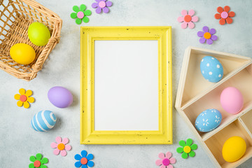 Easter holiday background with easter eggs and photo frame on table.