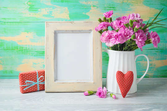 Mother's day background with photo frame, flowers, heart shape and gift box on wooden table