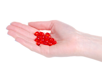 Red capsule medicine pharmacy in hand on white background isolation