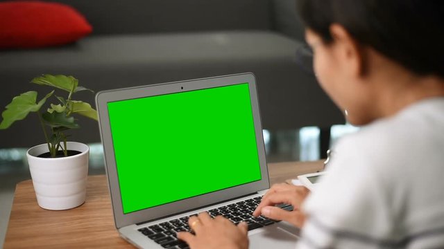 Close-up of a Woman's Hands Working on Green Screen on a Laptop. A Girl sitting table notebook female hands keyboarding laptop using texting pointing networking green screen chroma key chromakey.