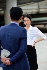 Debate between couples While the husband in the suit secretly holds cash behind The wife is...