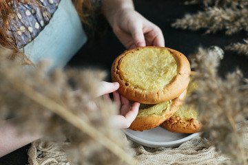 Girl puts on the table open pies with potatoes.