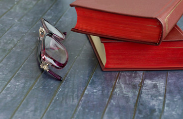 Fototapeta na wymiar Two books are on the surface and women's glasses