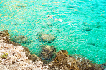 boy snorkeling in clear blue water top view