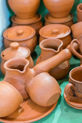 Fototapeta na wymiar Lots of traditional ukrainian handmade clay pottery production. brown pottery. Clay plates and cups. vertical photo