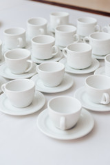 set of white cups on a white tablecloth 1