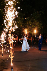 beautiful young newlywed couple with fire torches in their hands and fireworks 1