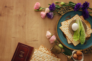 Pesah celebration concept (jewish Passover holiday). Translation for Hebrew Text over plate (Matzah) Matza and Traditional book with text in hebrew: Passover Haggadah (Passover Tale)