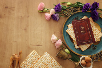 Fototapeta na wymiar Pesah celebration concept (jewish Passover holiday). Translation for Hebrew Text over plate (Matzah) Matza and Traditional book with text in hebrew: Passover Haggadah (Passover Tale)