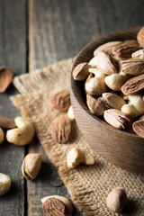 Healthy mix nuts on wooden background. Almonds, hazelnuts, cashews, peanuts, pistachios, brazilian nuts