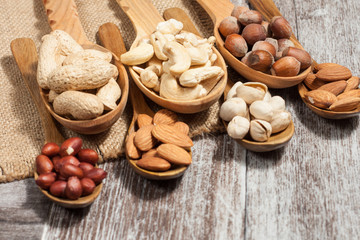 Healthy mix nuts on wooden background. Almonds, hazelnuts, cashews, peanuts, pistachios, brazilian nuts