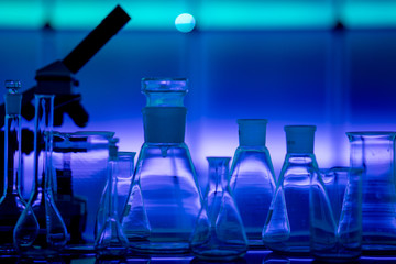 Empty chemical glassware on color background. Group of laboratory empty flasks   on color scientific background reflection on a table