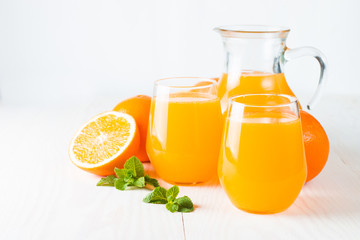 Close-up of a glass of orange juice with oranges fruits on wooden and stone background. Vitamins and minerals. Healthy drink and beverage concept.