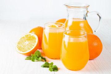 Close-up of a glass of orange juice with oranges fruits on wooden and stone background. Vitamins and minerals. Healthy drink and beverage concept.