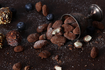 Homemade chocolates with almonds and cheese in vintage vases. Still life concept