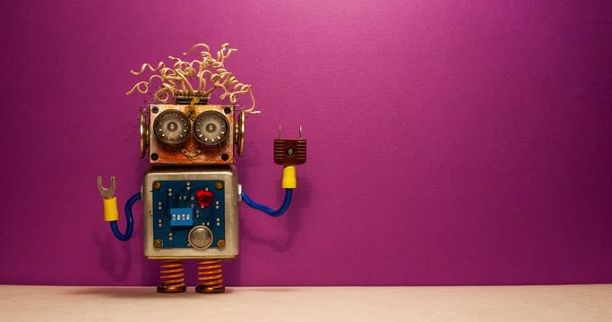 Funny robot rotates hand. Creative design robotic toy character smiley face on purple violet wall background. Copy space.