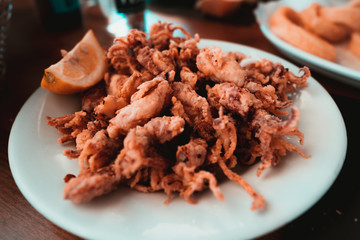 Plate of deep fried squids or Chipirones with lemon. Typical spanish food known as tapa