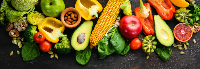 Foods containing natural fiber: avocados, kiwi, apple, tomatoes, spinach, paprika, orange, lemon. Top view. Free space for your text. On a brown background.