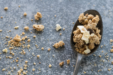 flat lay vintage dark silver spoon with heap cereals on concrete kitchen dresser