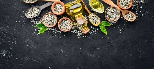 Seeds of sesame and sesame oil. On the old background. Top view. Free copy space.