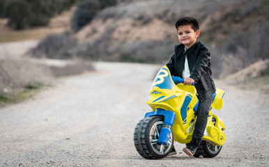 Little boy riding on motorcycle toy